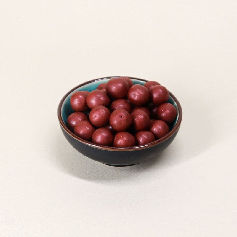 Billes de céréales croustillantes enrobées de chocolat noir nacrées rouges